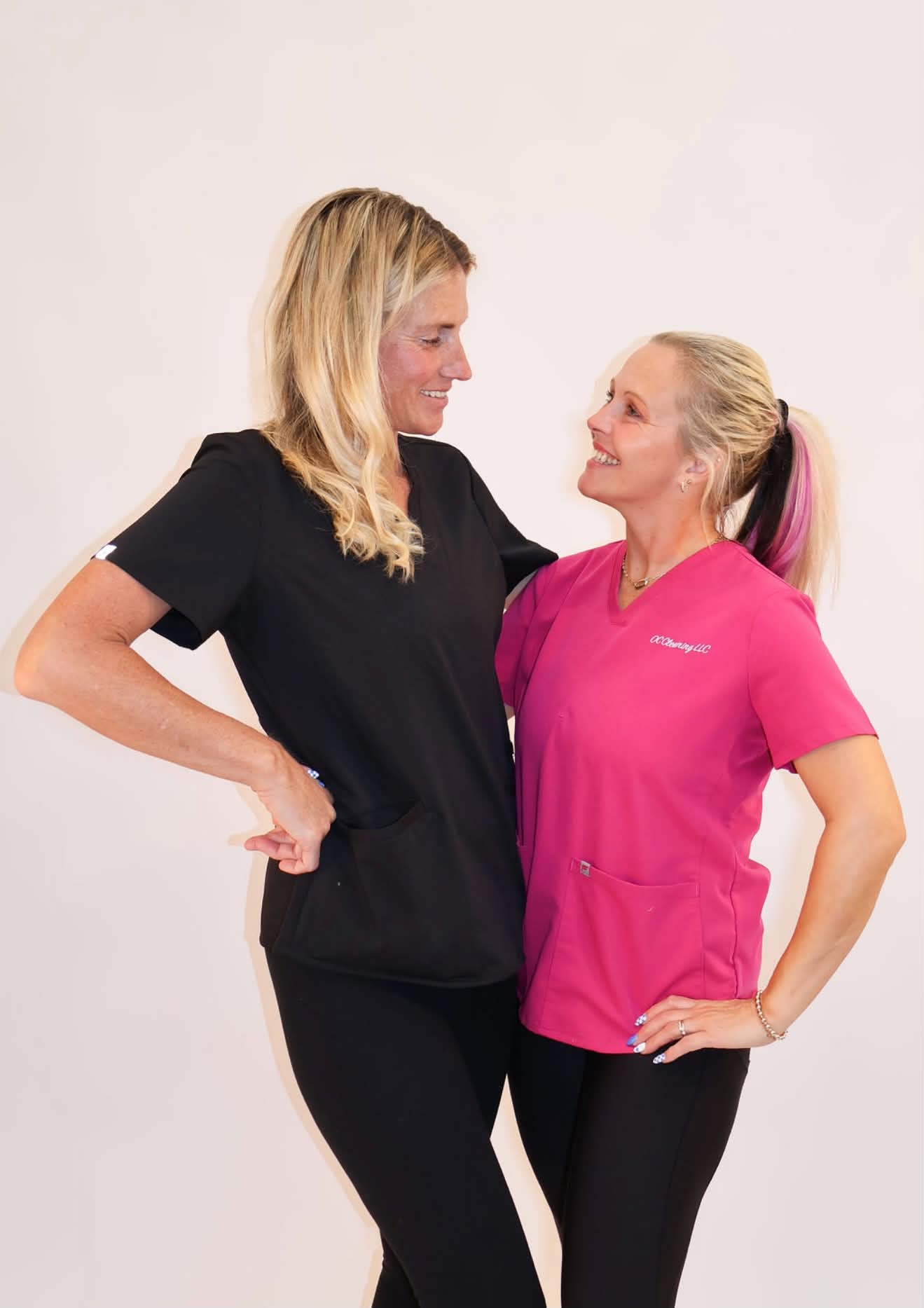 Two OC Cleaning teammates in black and pink uniforms